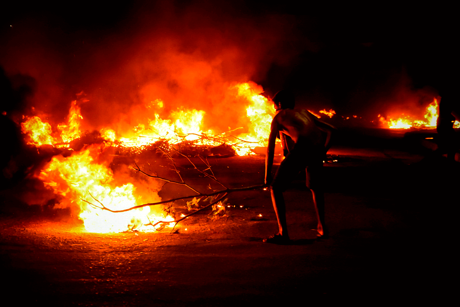 Amapaense alimenta fogo na barricada com madeira