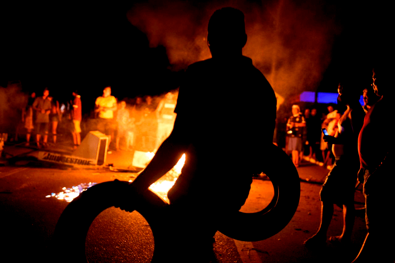 Person from Amapá carries a tire to a barricade